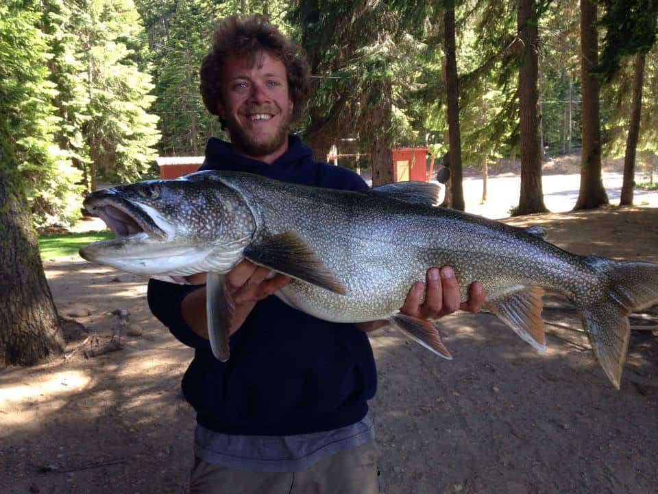 An angler holding a mackinaw trout caught in cultus lake.