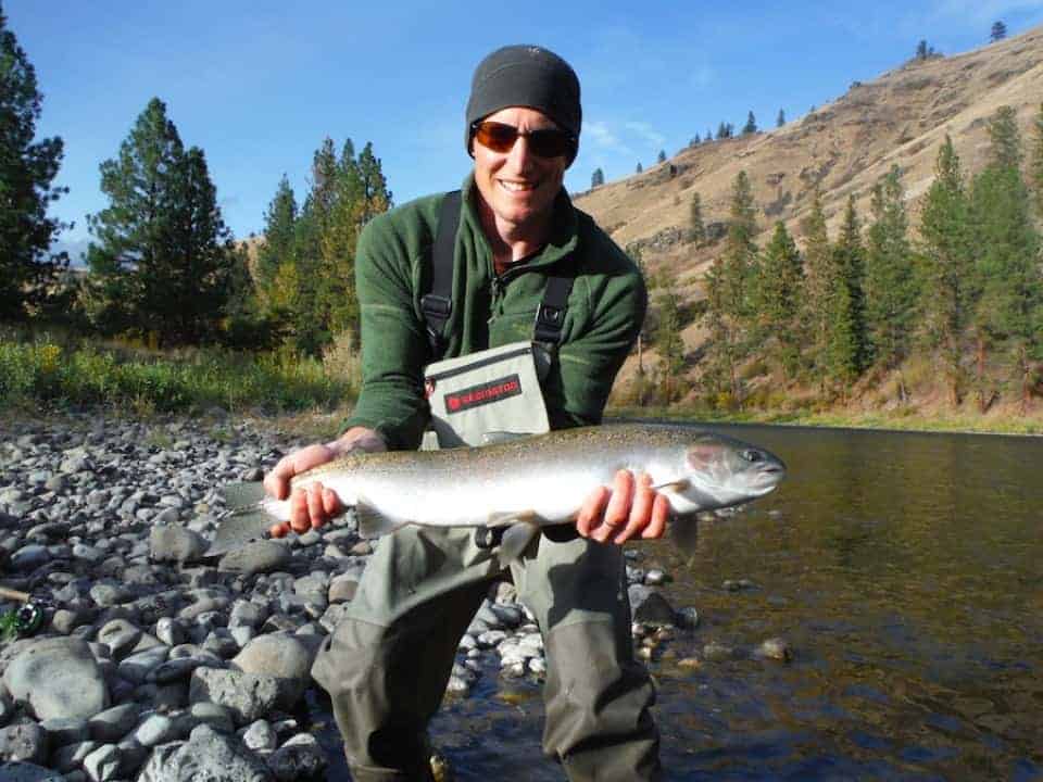 An angler holding a steelhead caught at Grande Ronde River.