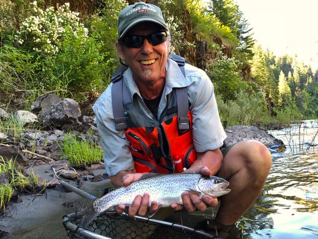 An angler holding a trout caught at grande ronde river.