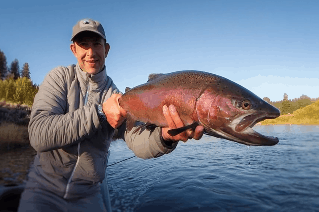 An angler holding a trout caught at Williamson River.