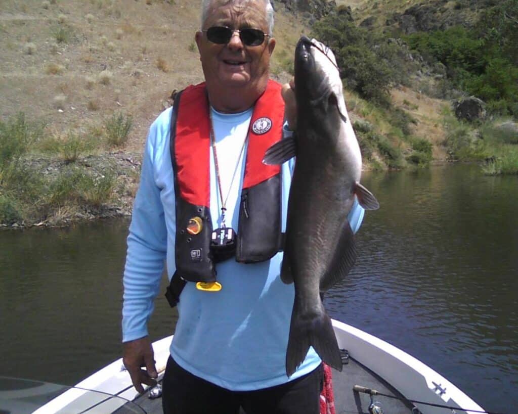 An angler holding a channel catfish caught on brownlee reservoir.