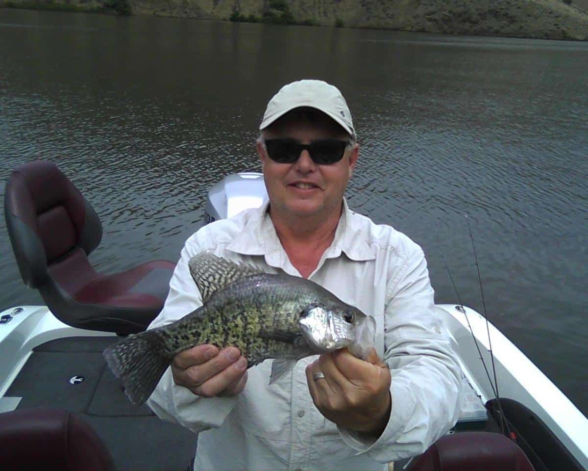 An angler holding a nice crappie caught in the pacific northwest.
