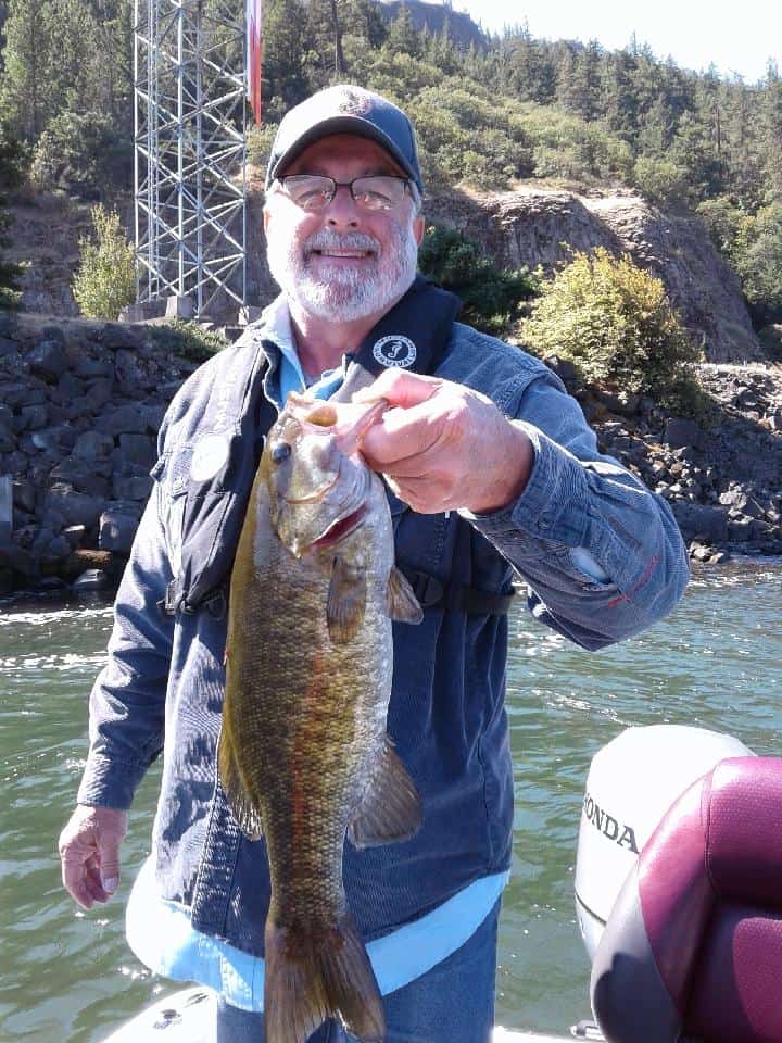 An angler holding a nice sized smallmouth bass caught in the Columbia River gorge.