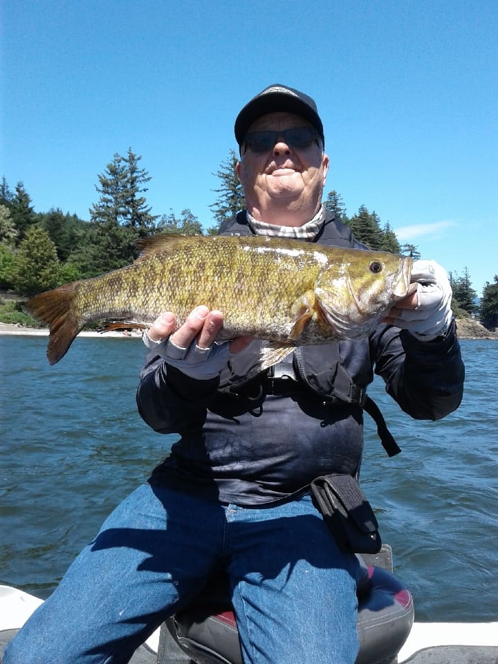 Angler holds a trophy sized smallmouth bass caught in the Columbia River in Hood River County.