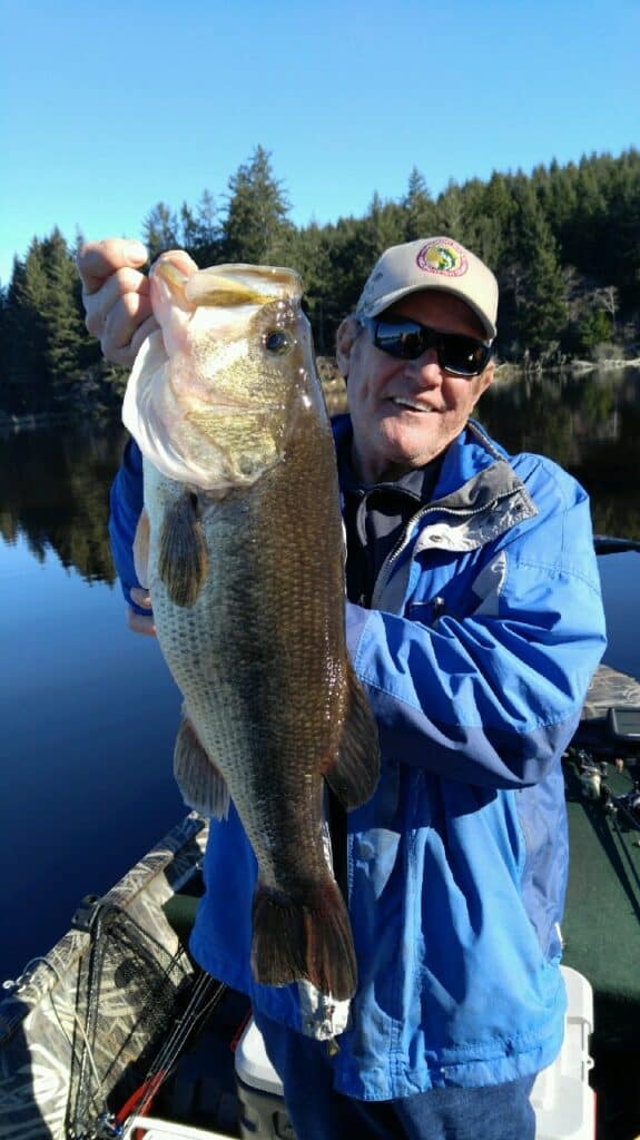 An angler holding a largemouth bass caught at cullaby lake.