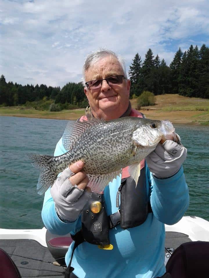 An angler holding a crappie caught on hagg lake.