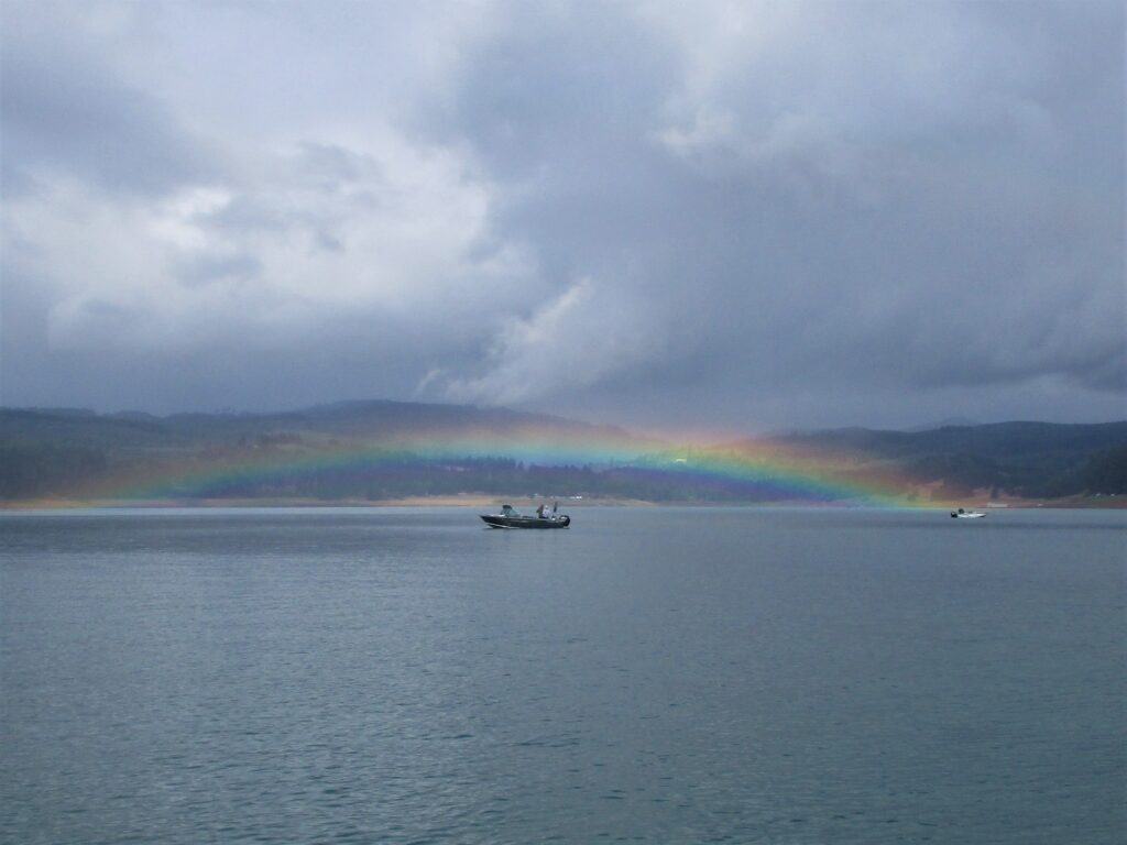 A rainbow curves over a fishing boat at Henry Hagg Lake in Oregon.