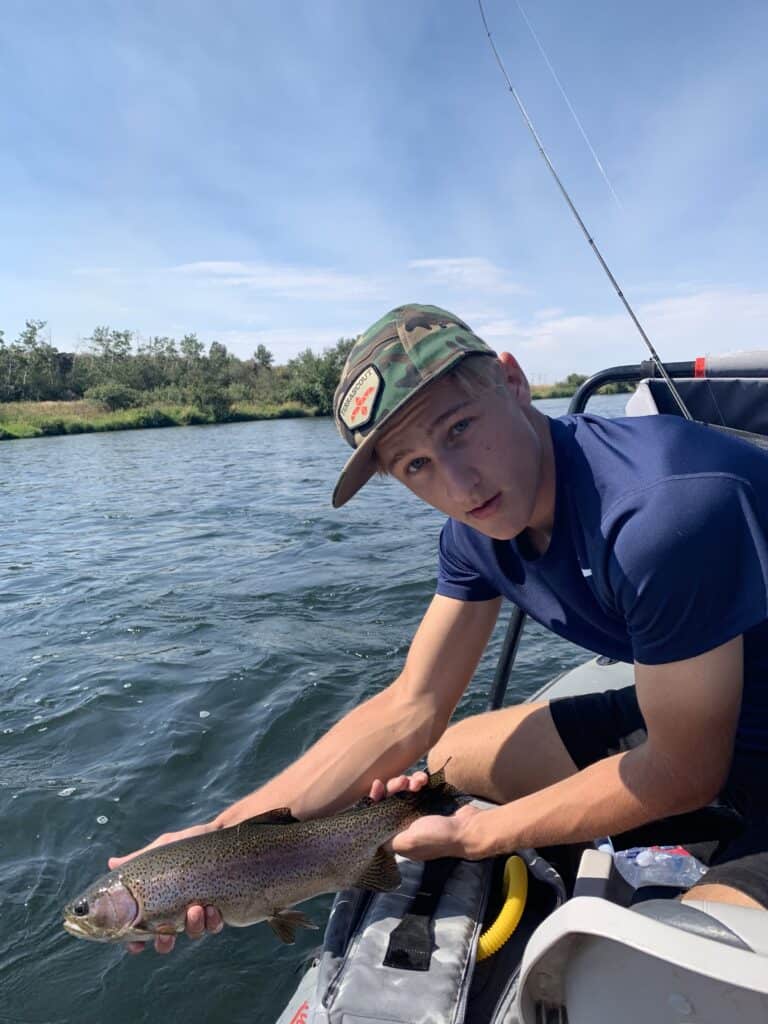 An angler releasing a rainbow trout caught on idaho's famous henry's fork.