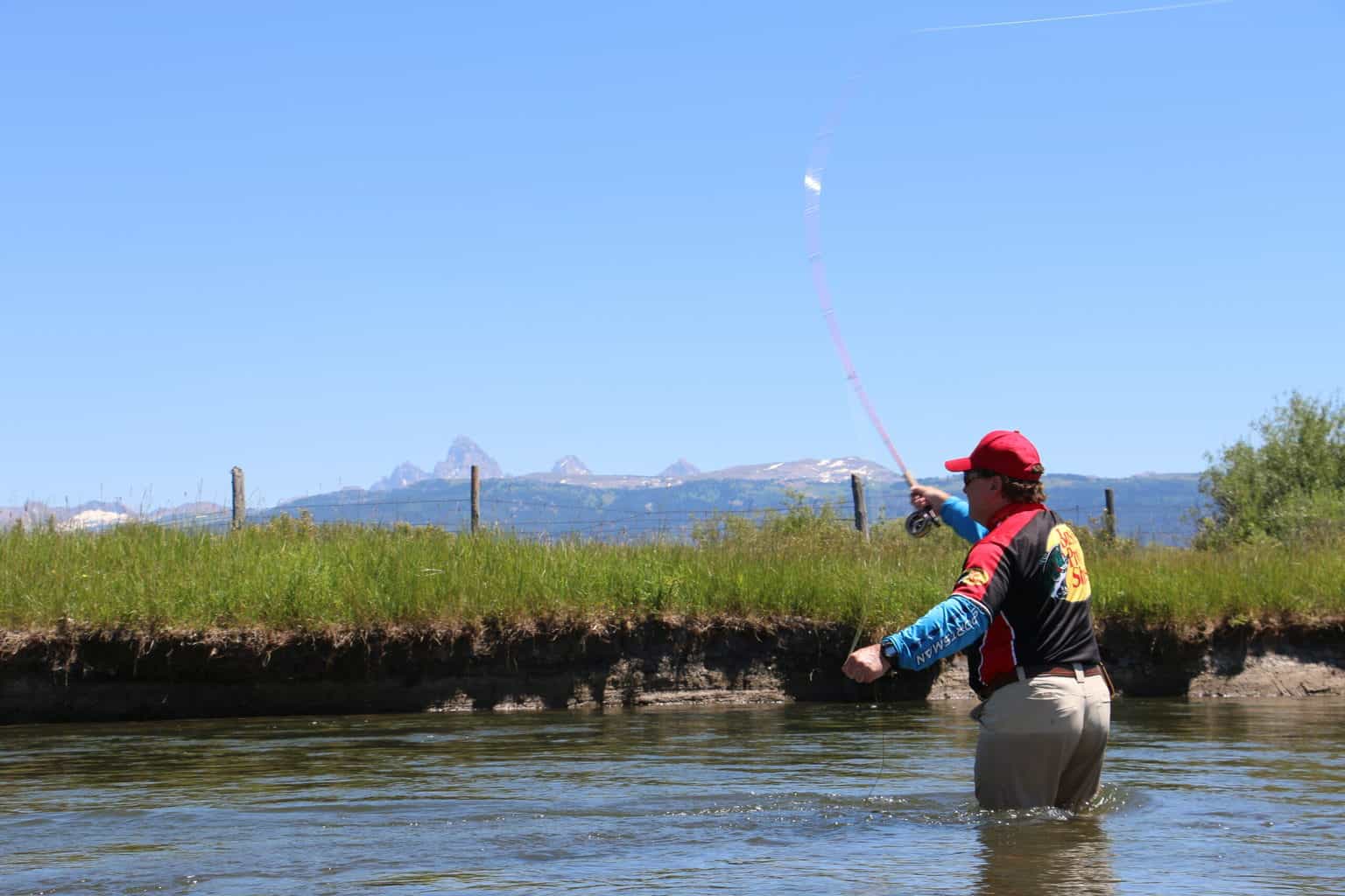 An angler fly fishing at teton river in southeastern idaho.