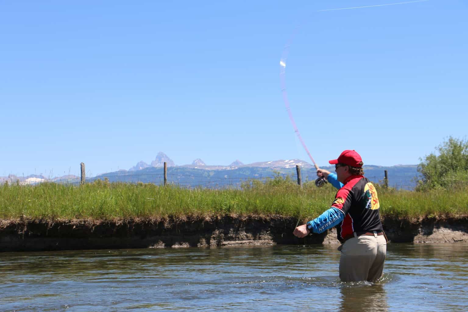 An angler fly fishing at teton river in southeastern idaho.