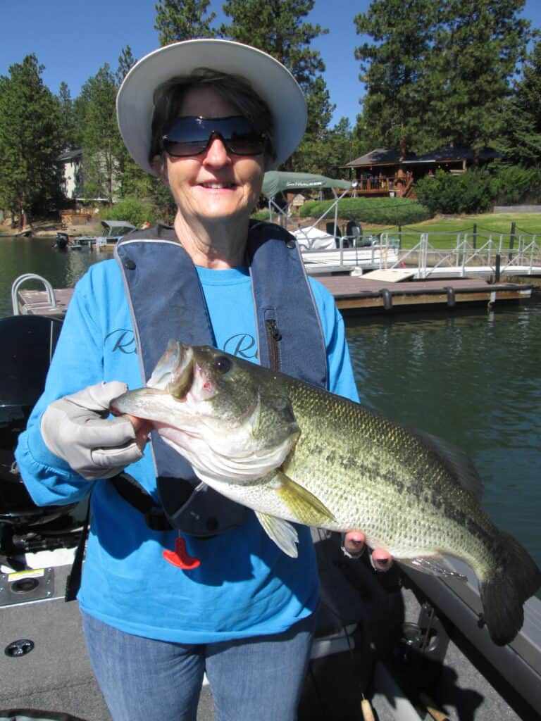 An angler holding a largemouth bass caught at pine hollow reservoir, oregon.