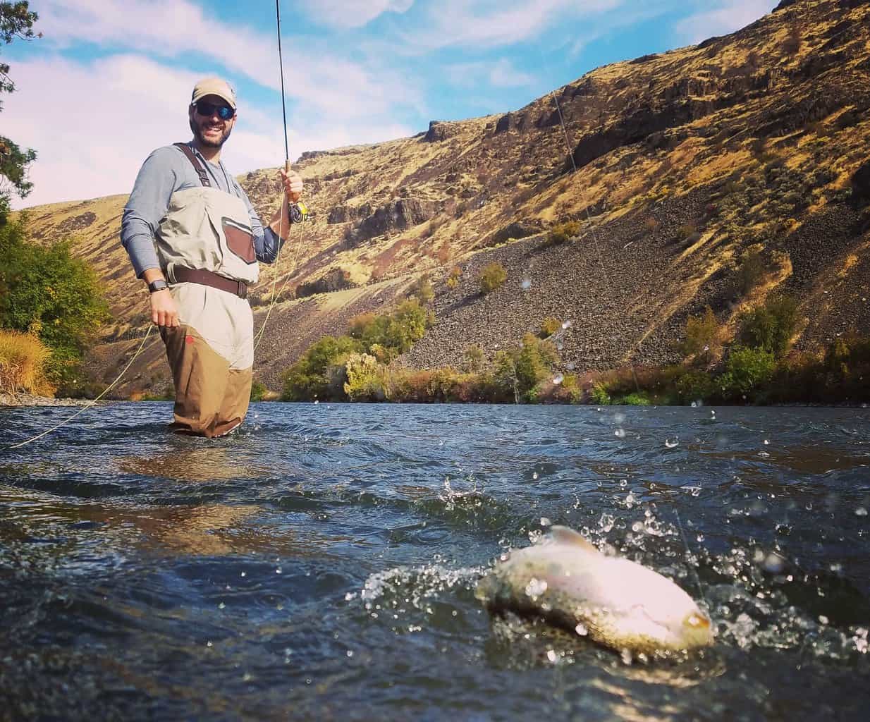 A fly angler landing a trout on the Yakima River.