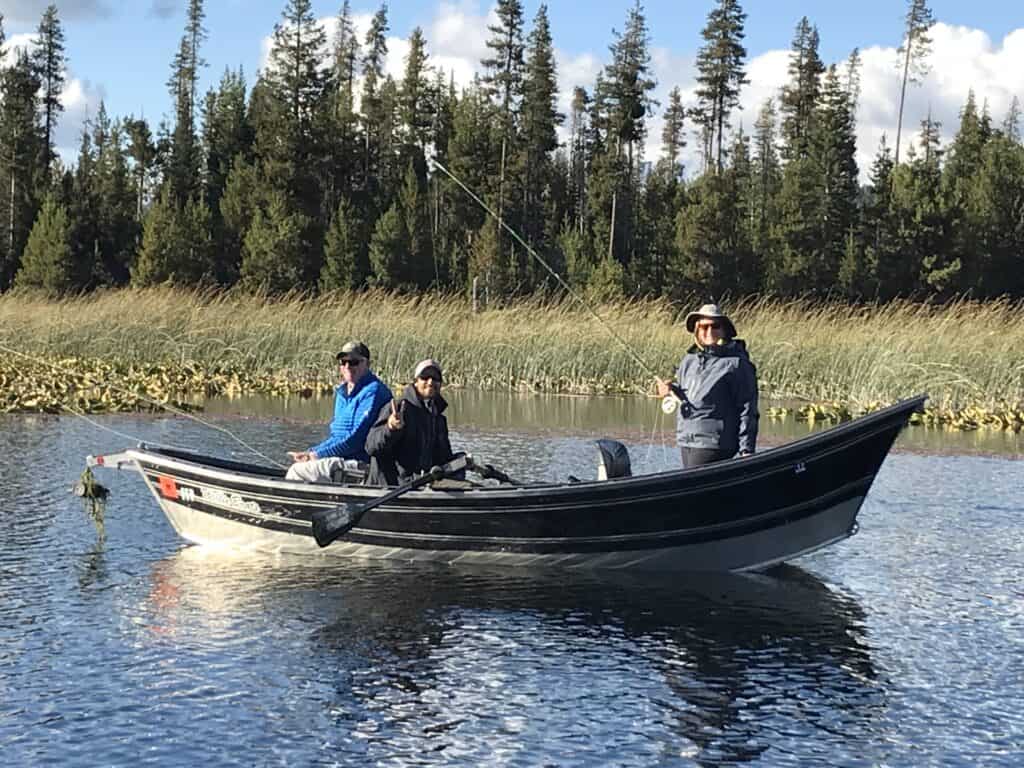 Anglers fly fishing from a drift boat on Hosmer Lake.