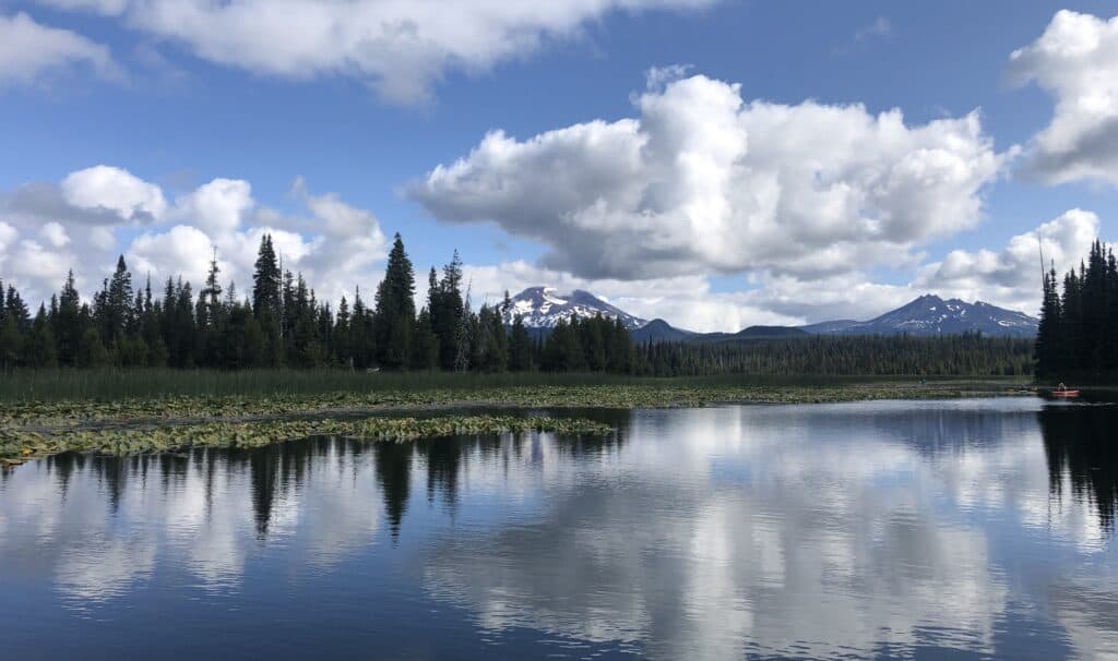 A scenic view of hosmer lake with mountains.
