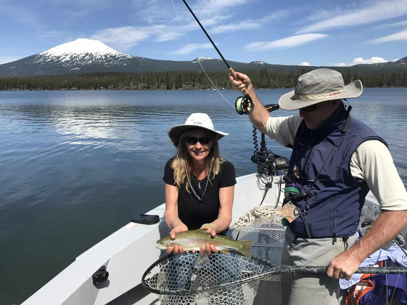 An angler holding a trout and an angler holding a rod at lava lake.