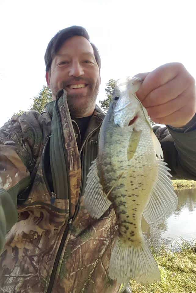 An angler holding a nice sized crappie caught at silver lake in cowlitz county, washington.