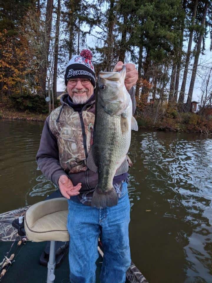 An angler holding a largemouth bass caught at silver lake.