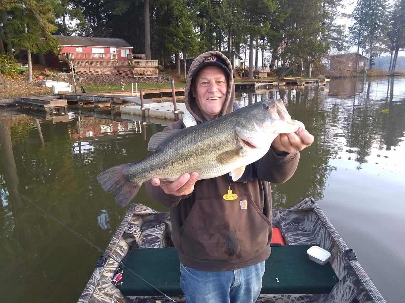 An angler holding a silver lake largemouth bass.