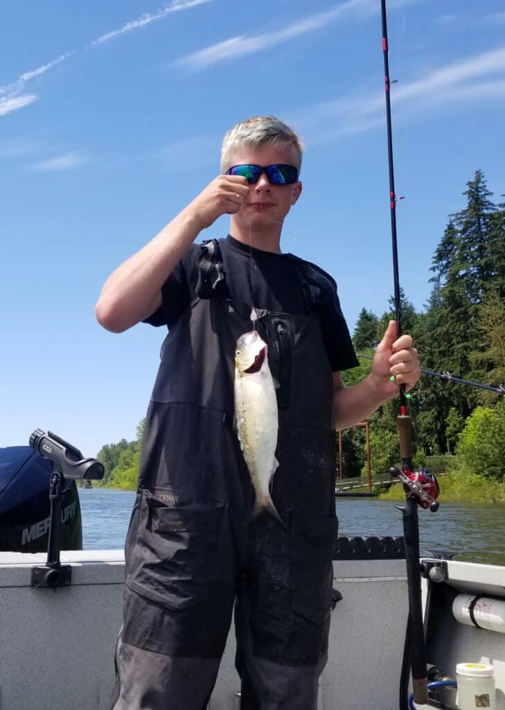 A boy with a shad caught in the Columbia River.