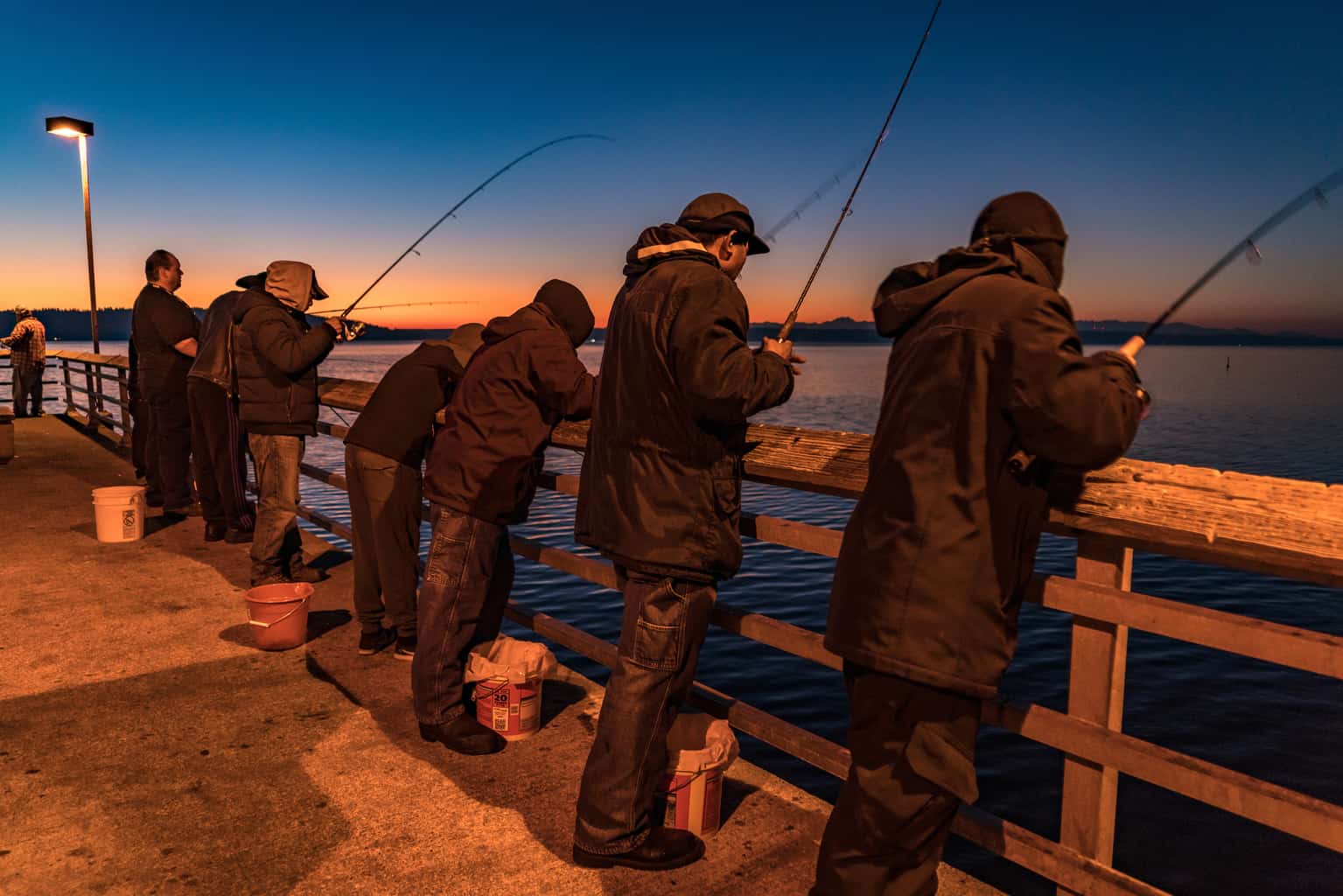 Anglers squid fishing from des moines beach pier in king county.