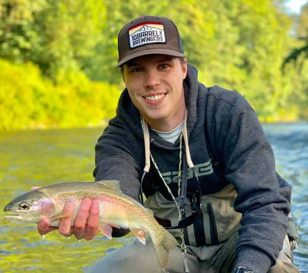 Fly angler with nice wild rainbow trout caught in the cedar river in king county, washington.