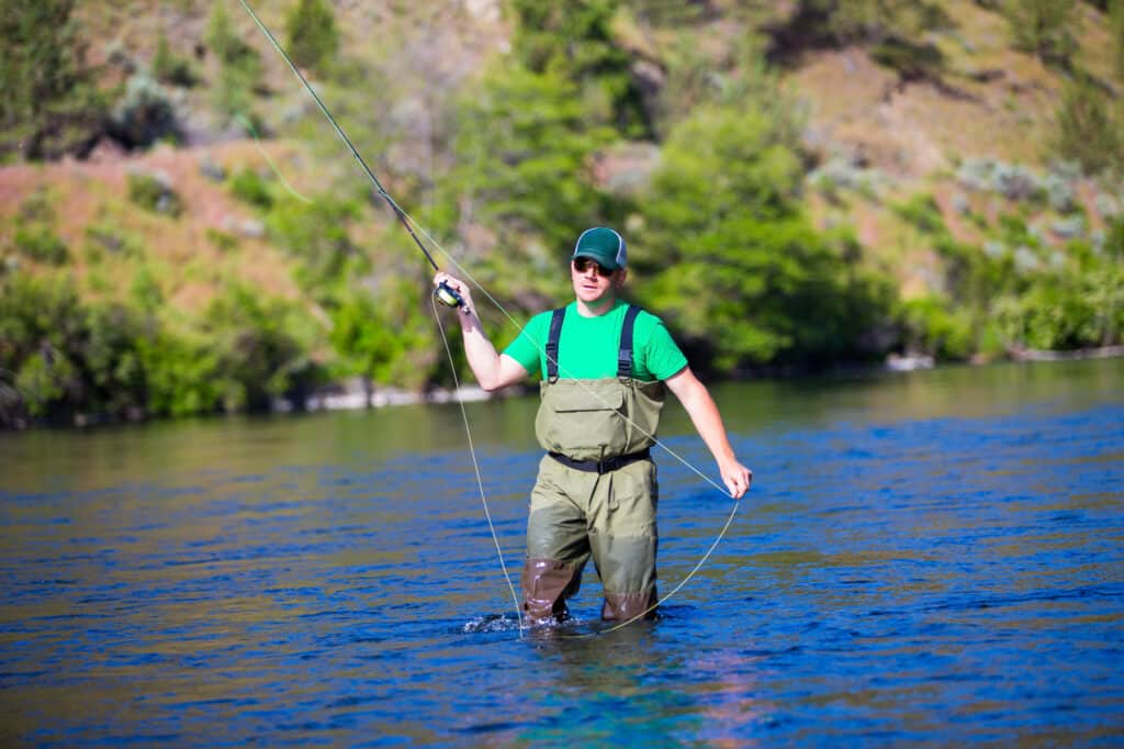 An angler fly casting at deschutes river.