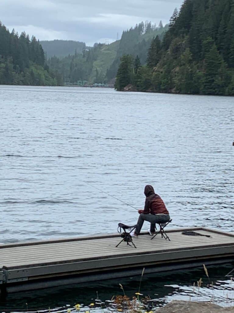 An angler fishes for trout from a fishing dock at the day use area on Faraday Road in the lower North Fork Reservoir.