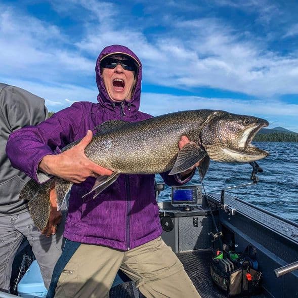 A surprised looking angler holding a surprised looking lake trout caught at Odell Lake.