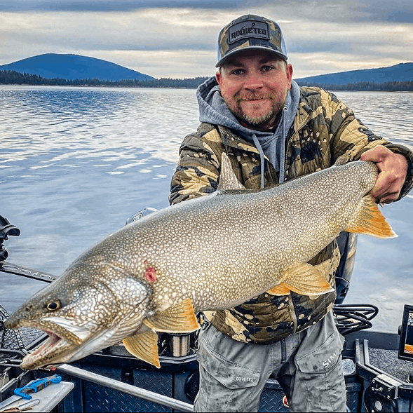 A fisherman holding a giant mackinaw trout caught at Odell Lake, Oregon.