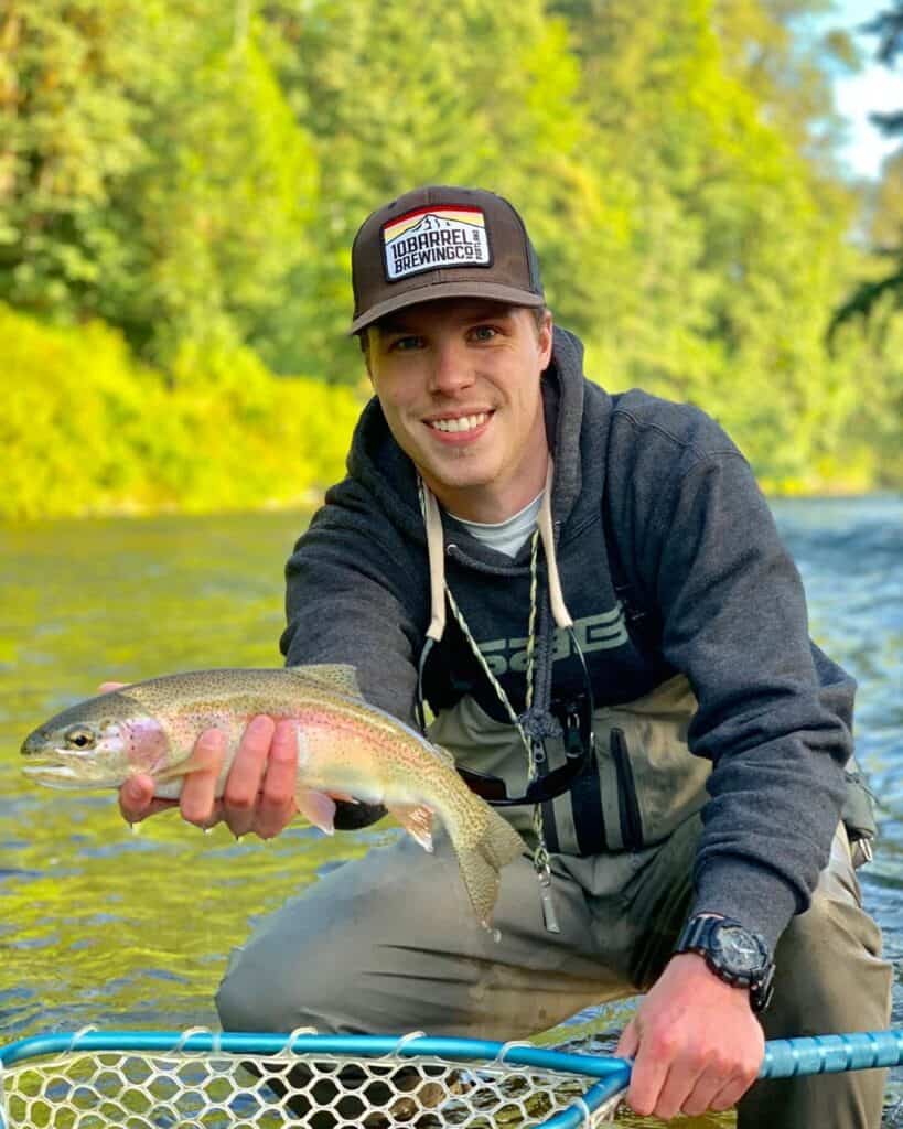 An angler holds a very nice wild rainbow trout caught fly fishing on the Cedar River in King County.