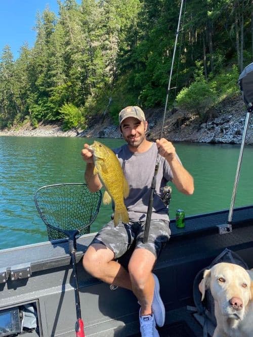 An angler in a boat holding a nice smallmouth bass at Lost Creek Lake.