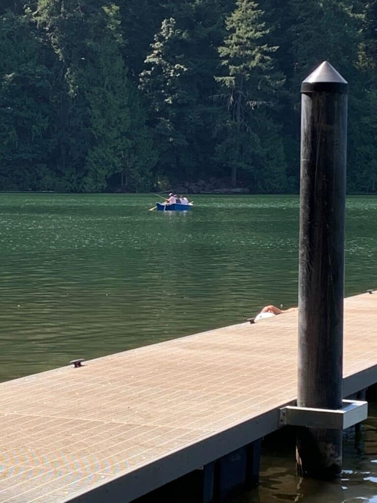 Anglers fish in a boat near the dock at battle ground lake.