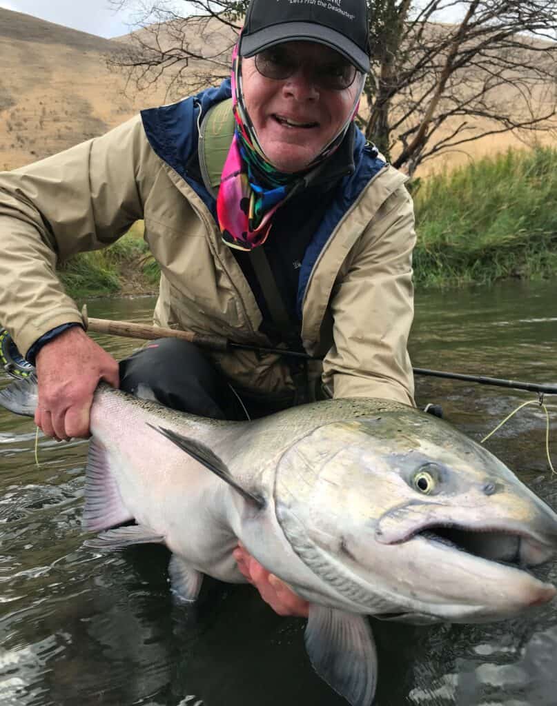 Large and bright deschutes river steelhead being held by an angler.