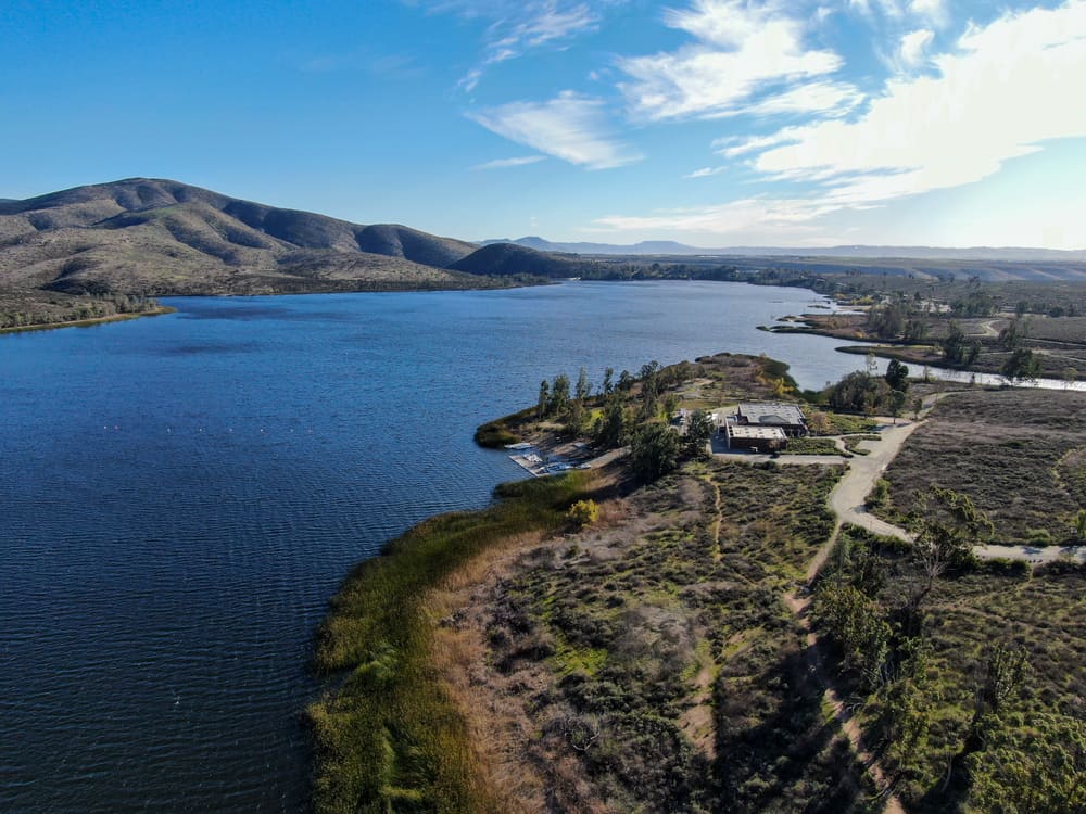 Aerial view of Otay Lake Reservoir with blue sky and mountain in the background near Chula Vista, California. Otay is a good bass fishing spot.