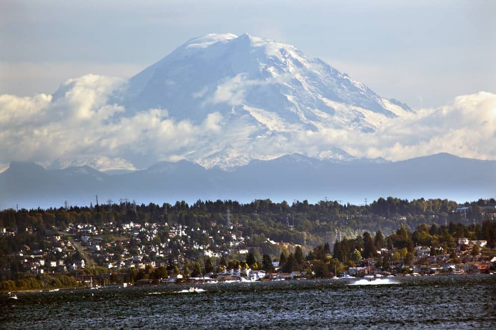 Mount Rainier looms large in the background with boats on Lake Washington in the foreground.