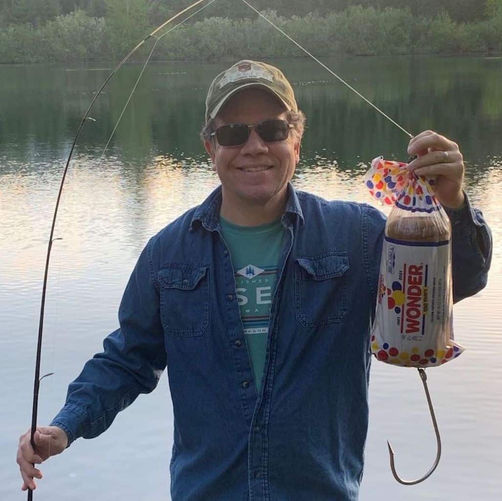 Angler holds gag lure made of bag of Wonder Bread and giant hook.
