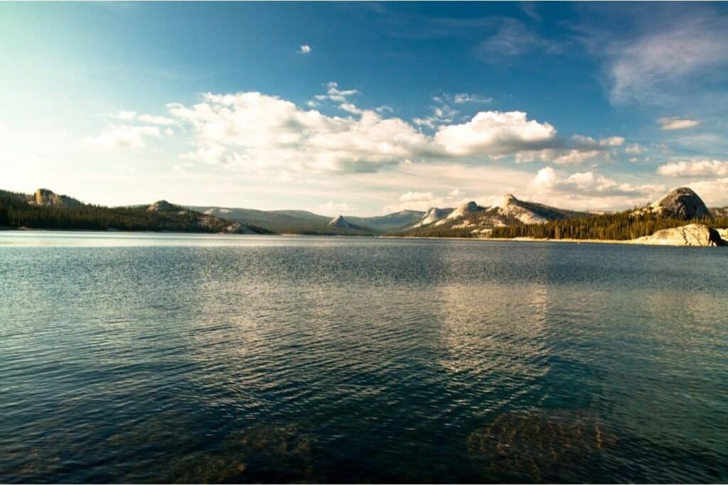 Scenic view of Courtright Lake with snow tinging the mountains beyond the water.