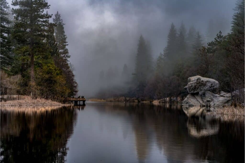 Anglers fish from a dock on a foggy day at Lake Fulmor.