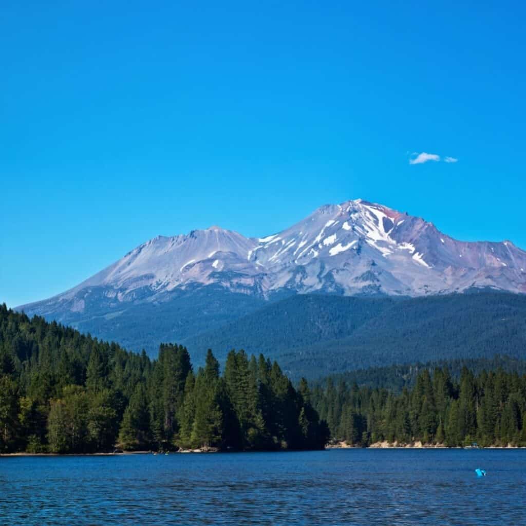 Bright blue skies and Mount Shasta rise up behind deep blue Lake Siskiyou.