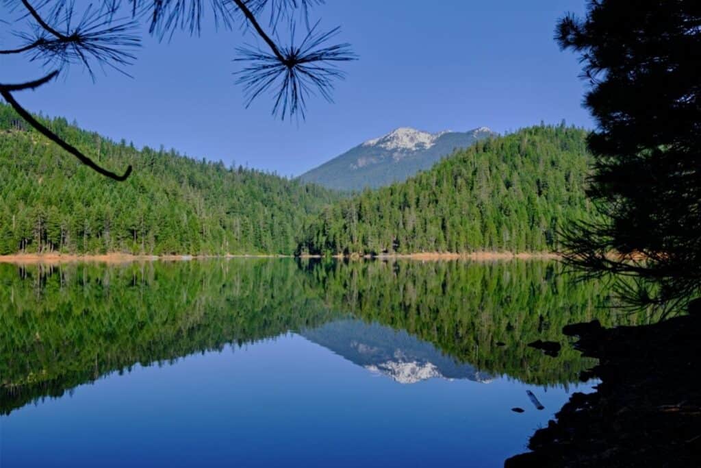 The Trinity Alps reflect in the serene surface of Trinity Lake.