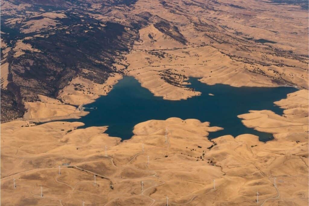 Aerial view of Los Vaqueros Reservoir surrounded by dry, golden hills.