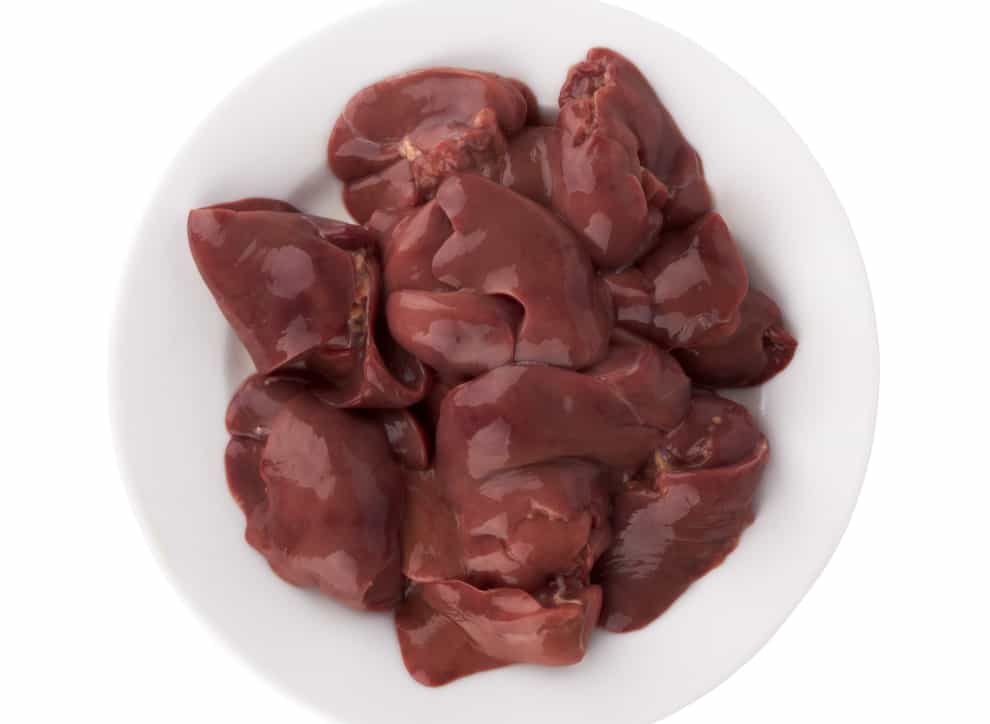 Fresh raw chicken liver in a bowl on a white background.