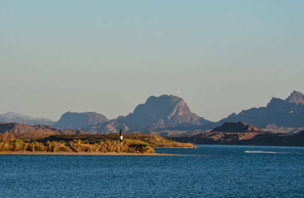 A fishing boat streaks across the blue waters of Lake Havasu on the border between Arizona and California.