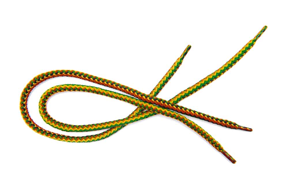 A pair of shoelaces looped over a white background.