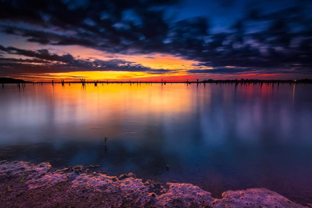 The sun barely rises over Benbrook Lake near Fort Worth, Texas, a very good bass fishing lake at this time of morning.