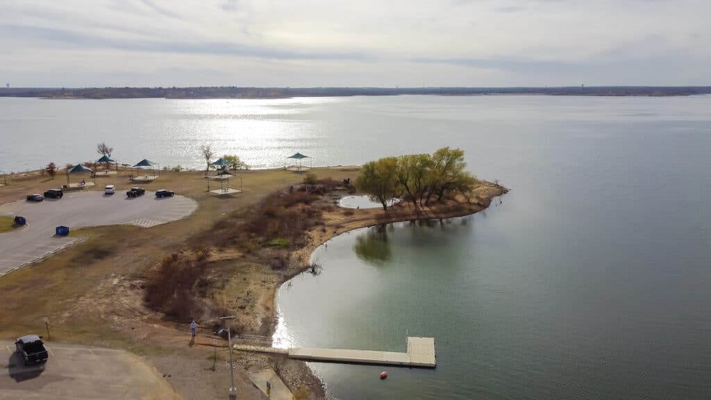 An aerial view of a peninsula with parked cars near the shores of Grapevine Lake, a good bass fishing lake near Dallas-Fort Worth.