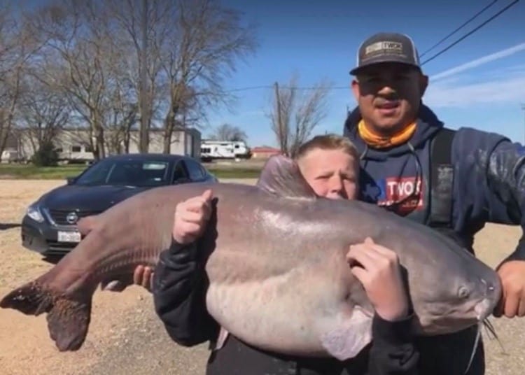 A boy holds a giant catfish caught in Texas.