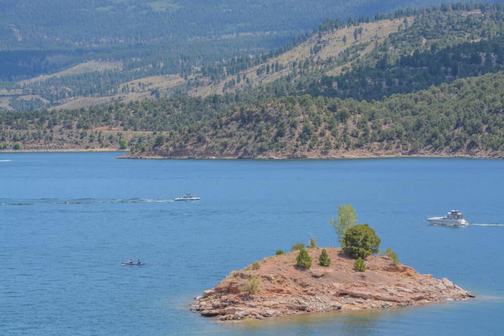 Boats from a small luxury yacht to a kayak dot the surface of Flaming Gorge Reservoir near an Island on the Utah end of the lake.