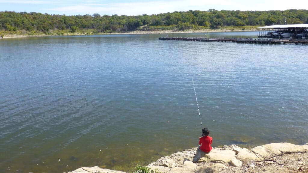 Boy fishing from the banks of Lake Texoma.