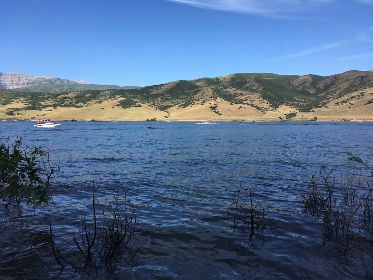 Fishing and power boats motor across Deer Creek Reservoir in Utah.